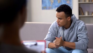 Anxious drug addicted black teenager suffering withdrawal, psychotherapy session